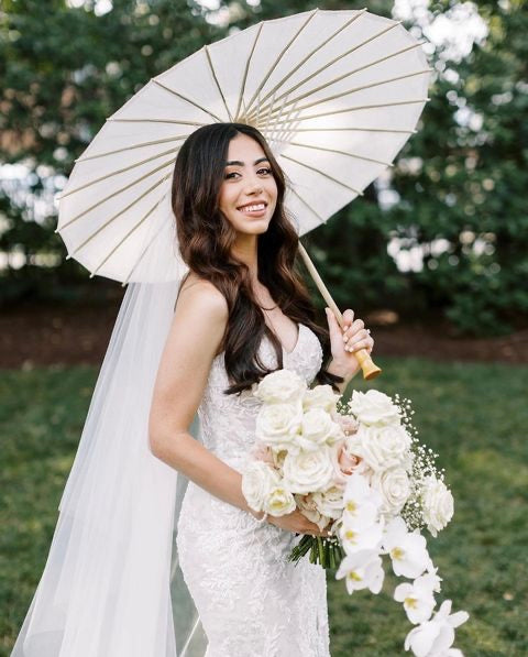 Wedding veil with hair down. Beautiful bridal portrait with rose bouquet and umbrella. 