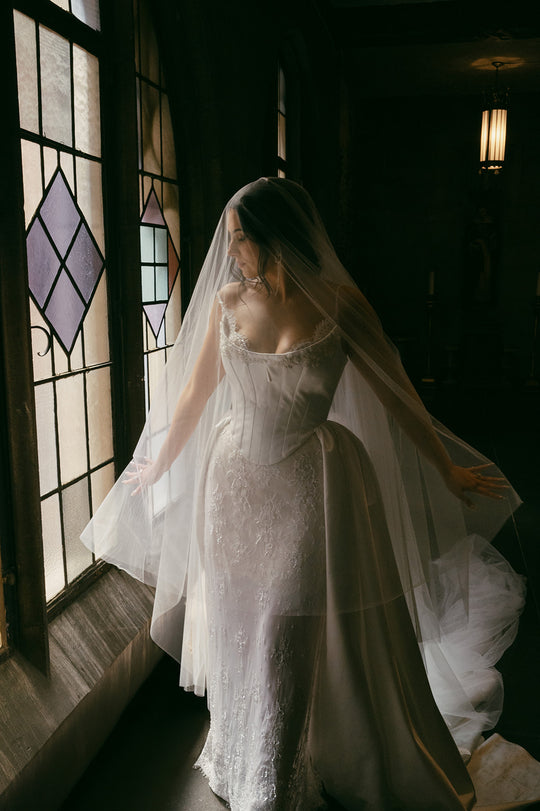 Bride wearing a sheer drop veil with corset wedding dress.